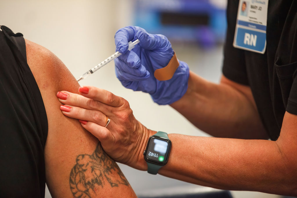 A man receives the Coronavirus (COVID-19) vaccine from...
